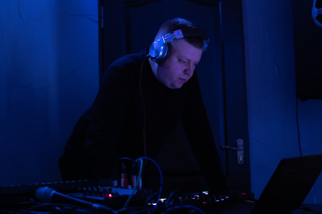 Sound engineer working with headphones at a mixing desk